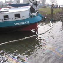 Er wordt een olie absorberend scherm aangelegt om de olie in de haven te houden